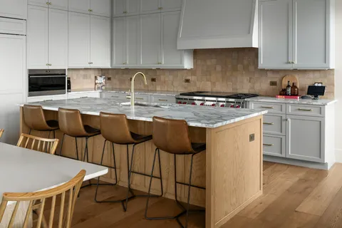 a kitchen with stainless steel appliances granite countertop a stove a sink and a white cabinets