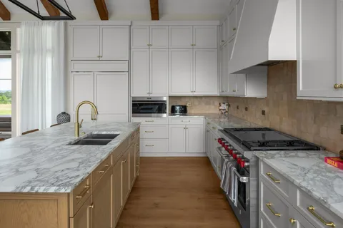 a kitchen with granite countertop a sink stove and cabinets