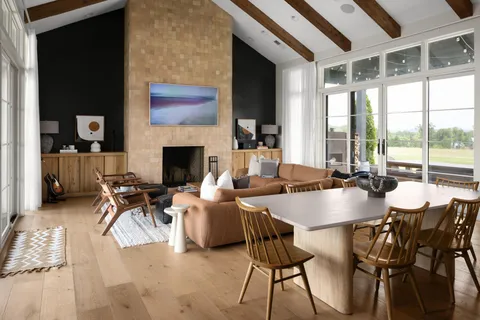 a dining room with furniture a fireplace and wooden floor
