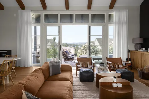 a living room with furniture large windows and a flat screen tv