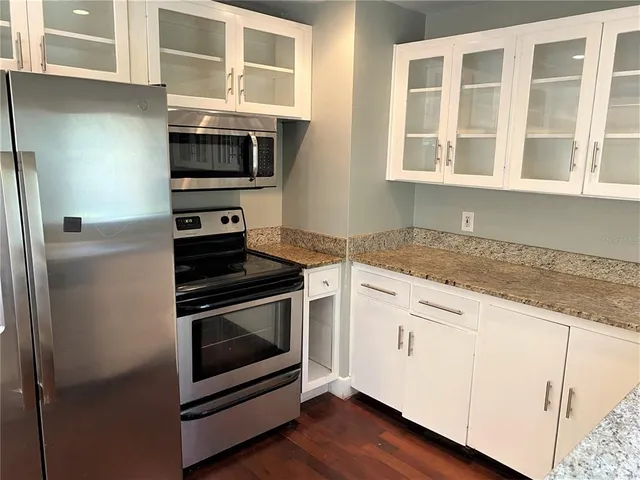 a kitchen with stainless steel appliances granite countertop a stove and a microwave