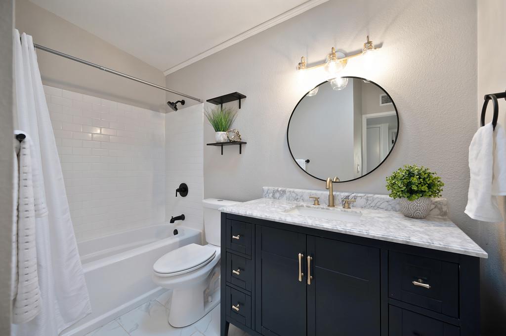 4812 Packard Court Carmichael, CA 95608 - Photo 22 of 39 a bathroom with a granite countertop toilet a sink and a mirror