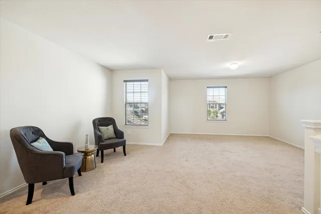 a view of a livingroom with chair and a window