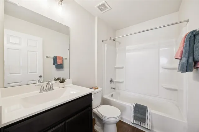 a bathroom with a sink a toilet a mirror and shower