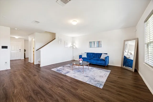 a living room with furniture and a wooden floor