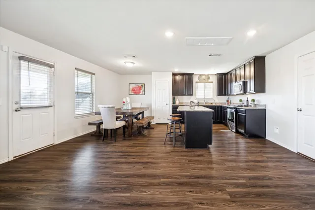 a living room with stainless steel appliances kitchen island granite countertop furniture and a kitchen view