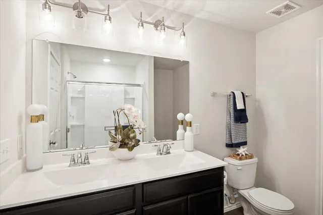 a bathroom with a sink vanity mirror and toilet
