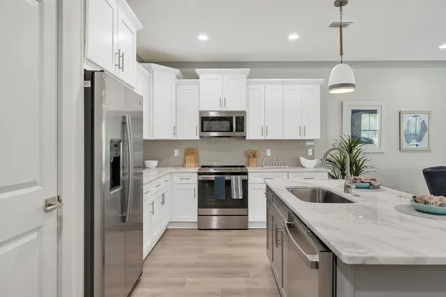 a large kitchen with cabinets chairs and wooden floor