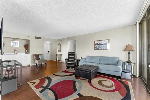 a living room with furniture and a wooden floor