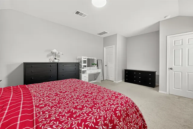 a large bedroom with a bed and a view of bathroom