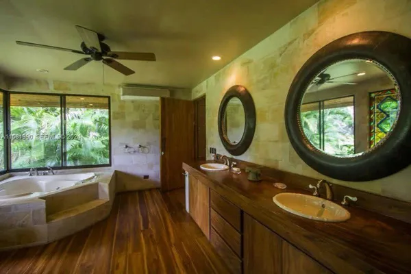 a bathroom with a granite countertop toilet a mirror and a tub