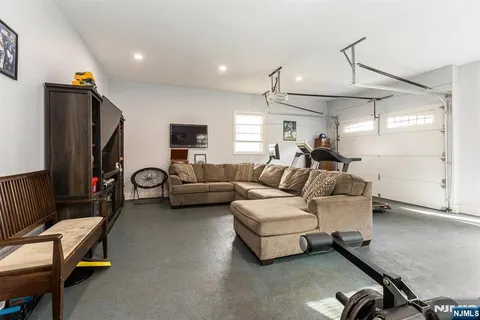 a living room with furniture gym equipment and a large window