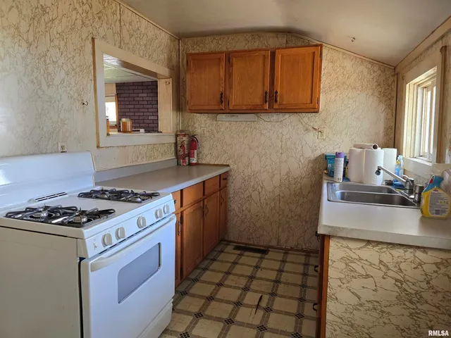 a kitchen with a stove a sink and a cabinets