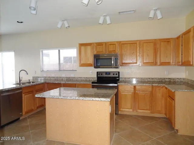 a kitchen with granite countertop a sink and a stove top oven