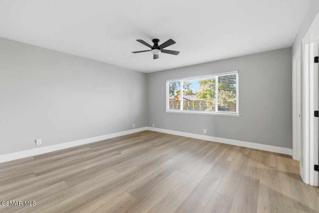 1069 Donner Avenue Simi Valley, CA 93065 - Photo 13 of 24 an empty room with wooden floor ceiling fan and windows