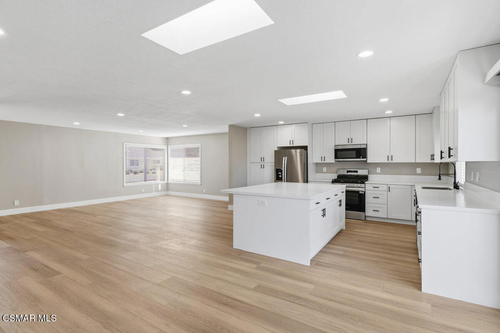 1069 Donner Avenue Simi Valley, CA 93065 - Photo 8 of 24 a large kitchen with stainless steel appliances granite countertop a large counter top and a stove top oven