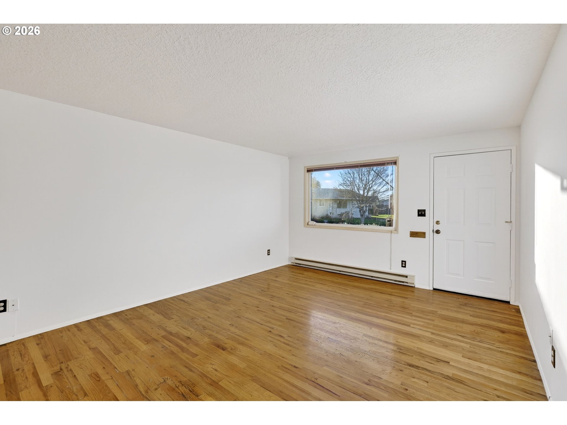 1620 Thompson Road Woodburn, OR 97071 - Photo 6 of 30 a view of an empty room with wooden floor and window