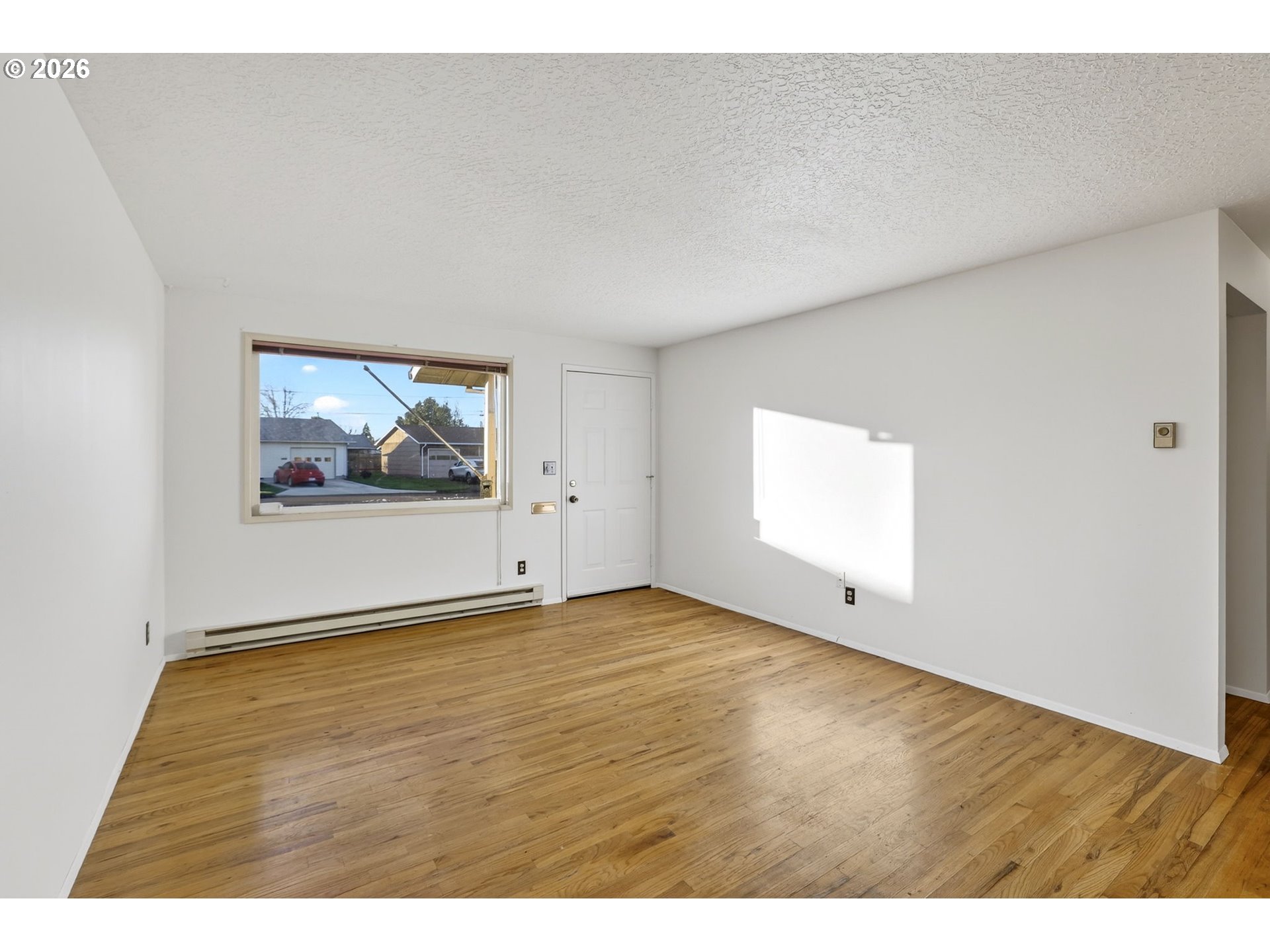 1620 Thompson Road Woodburn, OR 97071 - Photo 7 of 30 a view of an empty room with wooden floor and a window