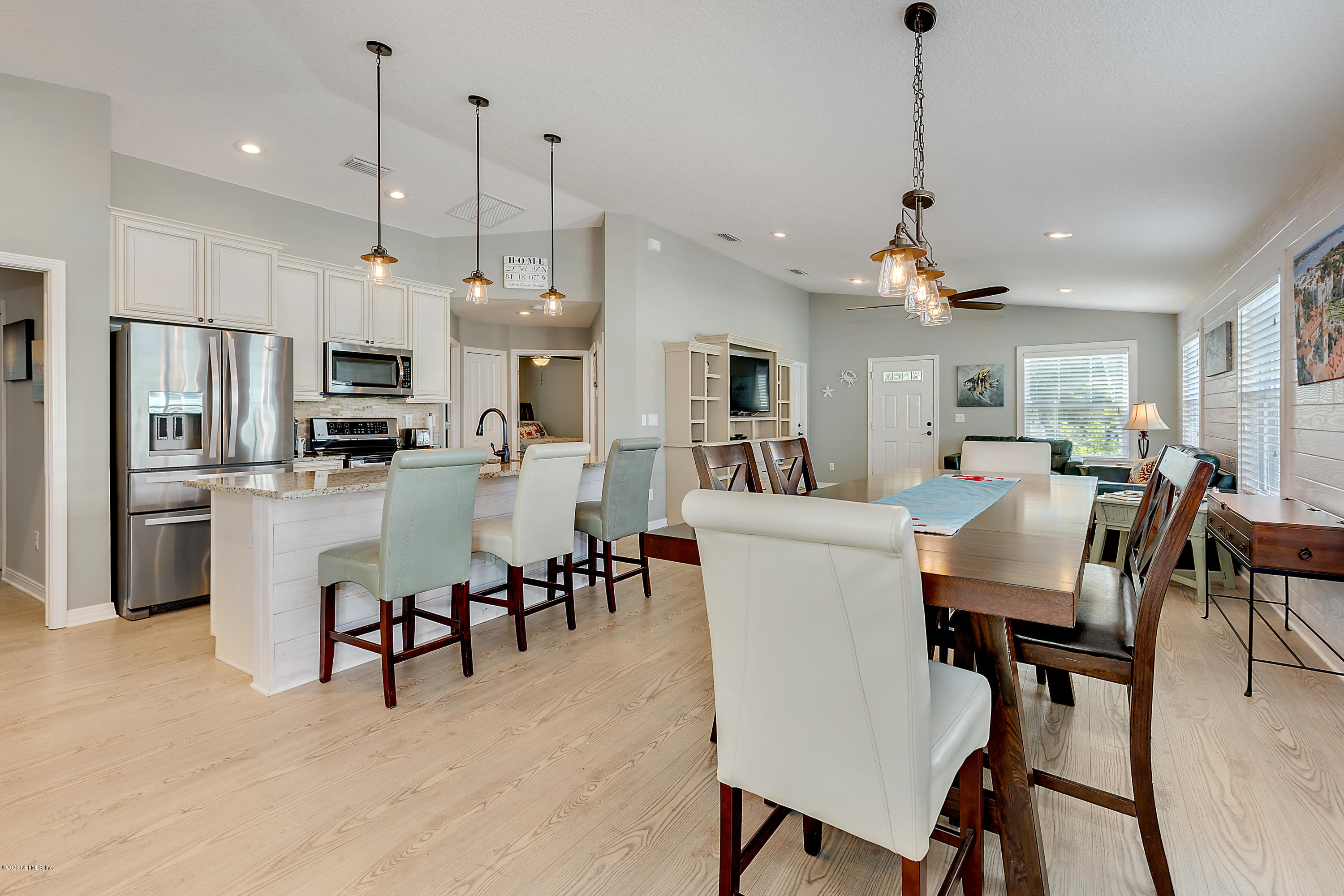 a view of dining room and livingroom with furniture wooden floor a chandelier