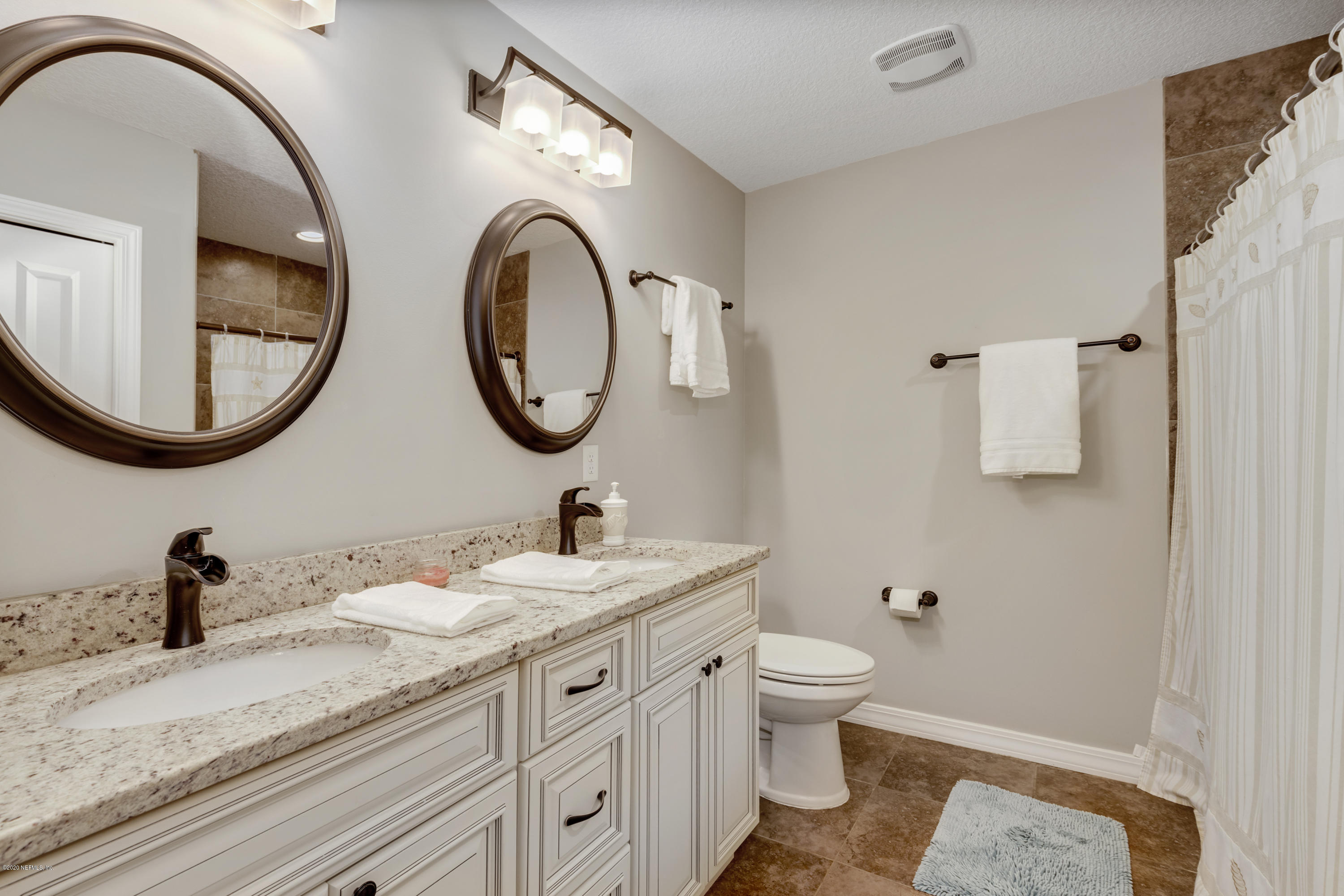 405 2nd Street St. Augustine, FL 32084 - Photo 14 of 32 a bathroom with a granite countertop toilet a sink and a mirror