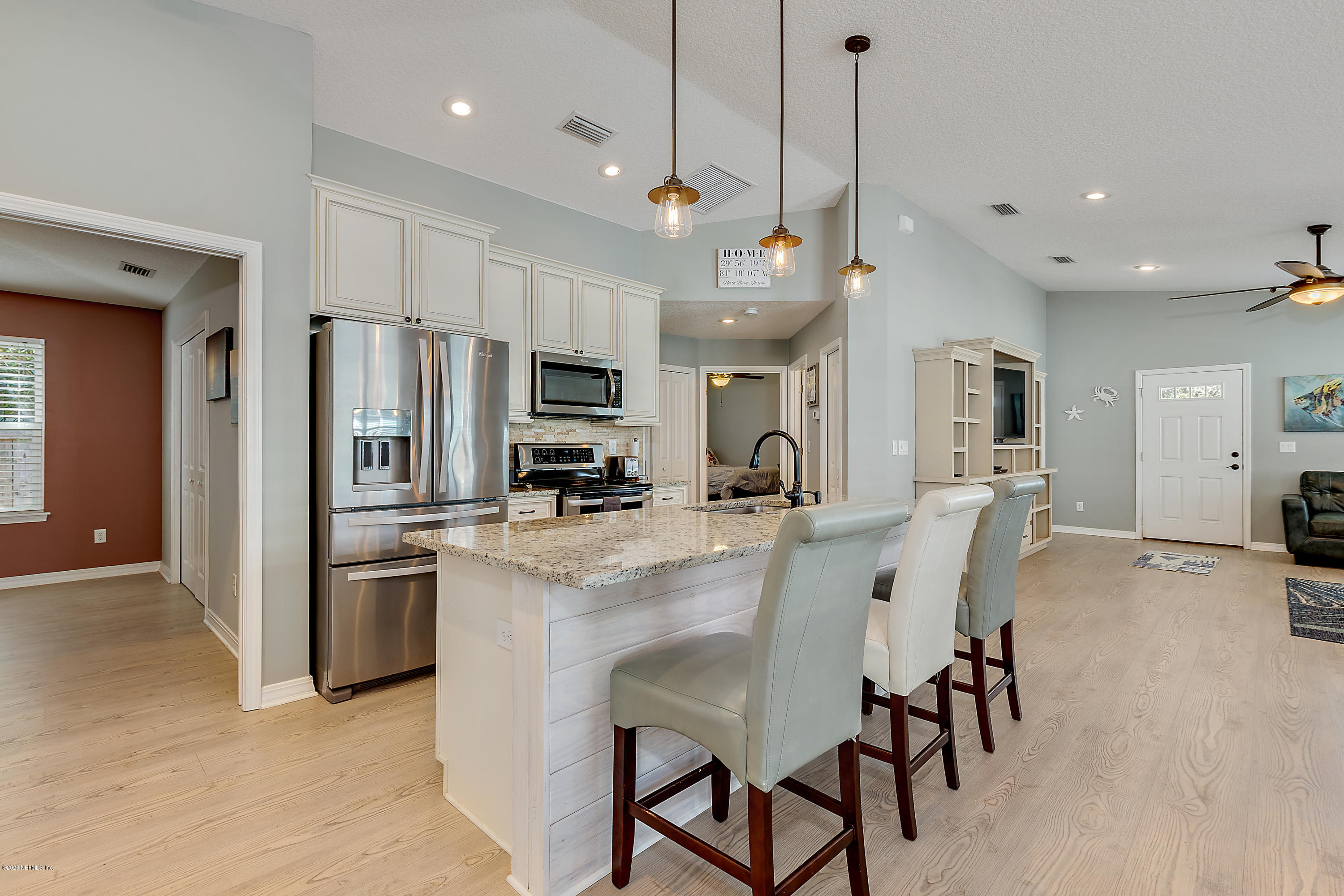 405 2nd Street St. Augustine, FL 32084 - Photo 9 of 32 a kitchen with stainless steel appliances kitchen island granite countertop a dining table chairs refrigerator and microwave