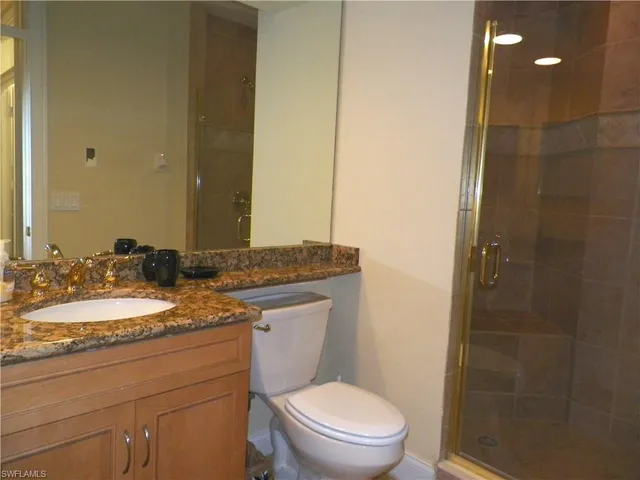 a bathroom with a granite countertop sink toilet and shower