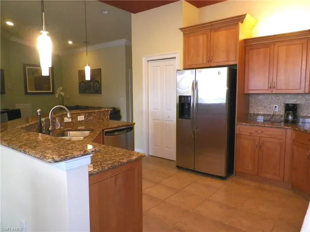 a kitchen with stainless steel appliances granite countertop a refrigerator a sink and a stove