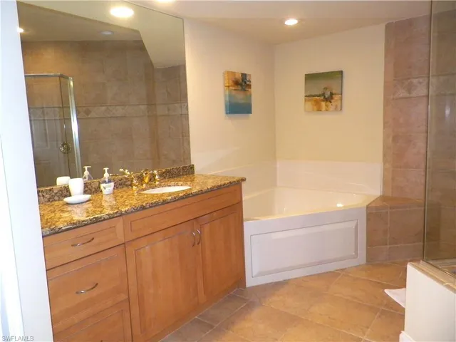 a bathroom with 2 sink tub and a mirror