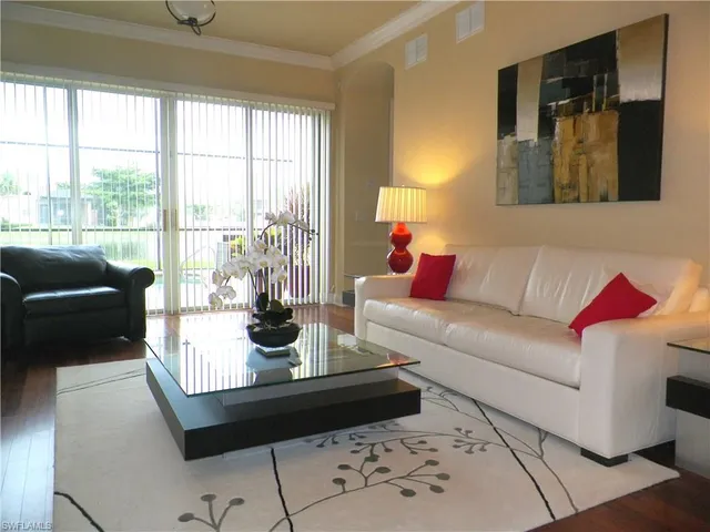 a living room with furniture and a floor to ceiling window