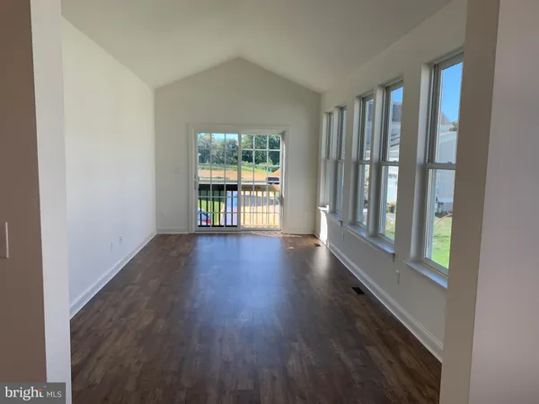 an empty room with closet and windows