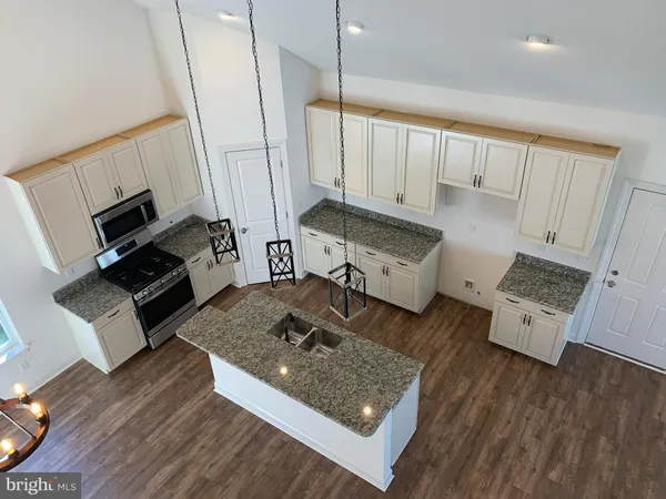 a bathroom with a granite countertop sink toilet a mirror and shower