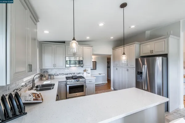 a kitchen with stainless steel appliances granite countertop a stove refrigerator and cabinets