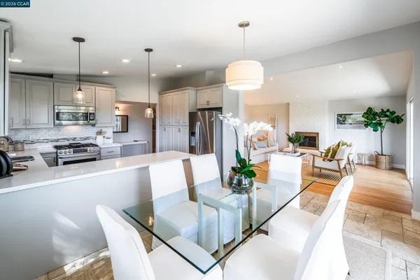 a view of a dining room and livingroom with furniture wooden floor a chandelier