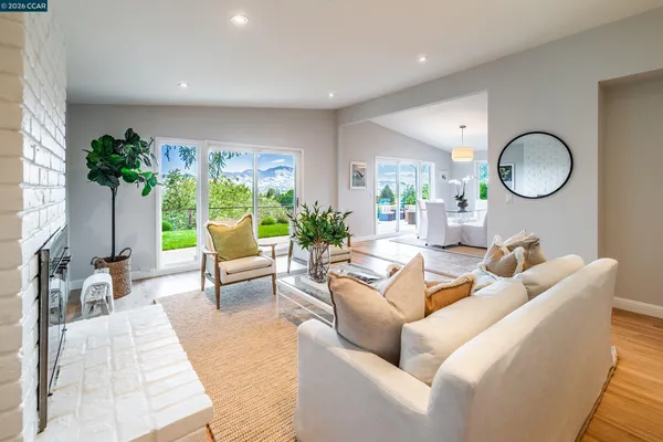 a living room with furniture a potted plant and a large window