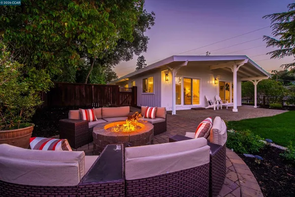 a view of a house with backyard and sitting area