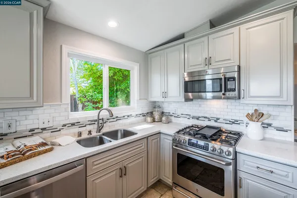 a kitchen with a sink stove top oven and cabinets