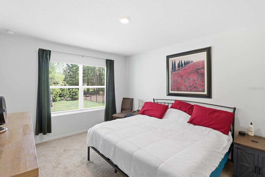 660 Hickory Course Loop Ocala, FL 34472 - Photo 28 of 45 a bedroom with a large bed and a large window