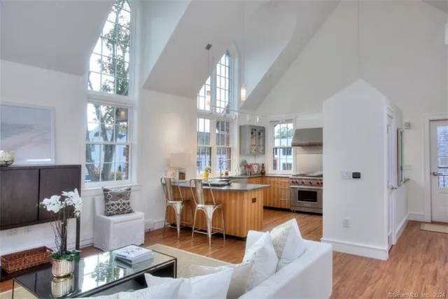 a living room with furniture a chandelier and kitchen view