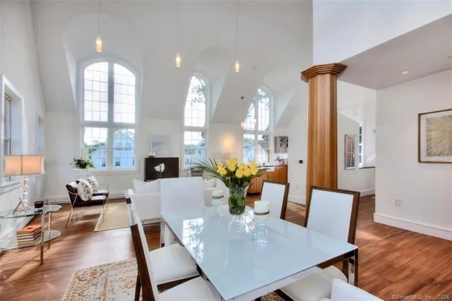 a view of a dining room with furniture a potted plant and wooden floor
