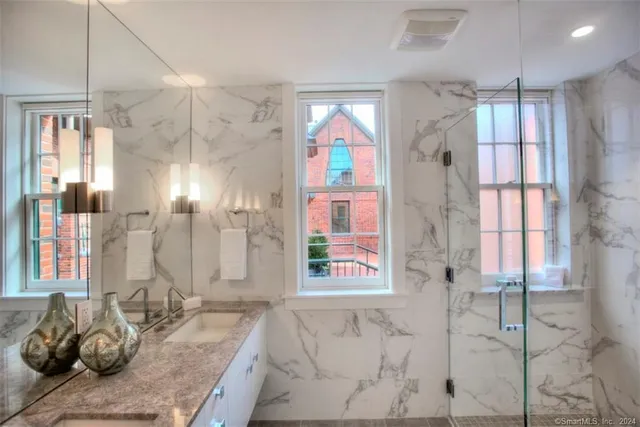 a bathroom with sink shower and a mirror