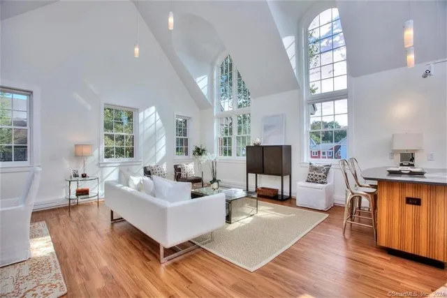 a living room with furniture flat screen tv and wooden floor