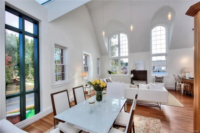 a view of a dining room with furniture a potted plant and wooden floor