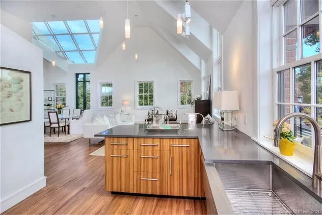 a living room with furniture a table and kitchen view