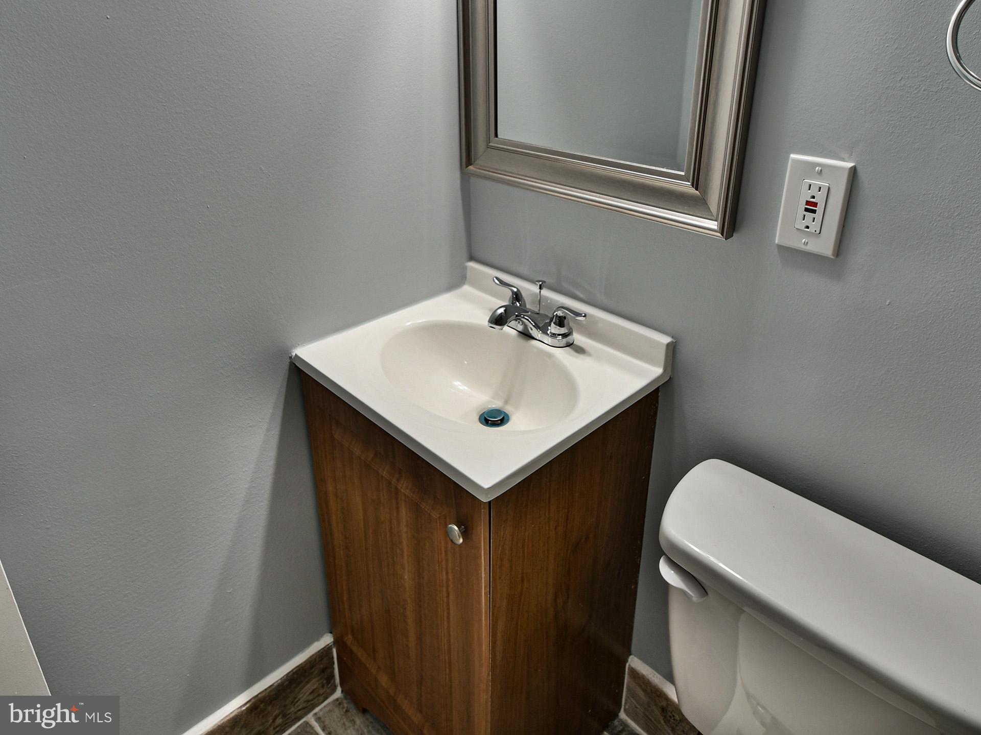 6308 Larwin Drive, Unit (BASEMENT) Temple Hills, MD 20748 - Photo 15 of 23 a bathroom with a sink a toilet and vanity