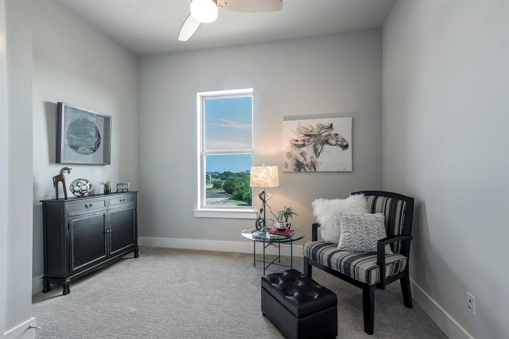 770 North Plano Road, Unit 303 Richardson, TX 75081 - Photo 17 of 26 This room features light grey walls and light grey carpet, a window with a view of greenery and sky, and a ceiling fan