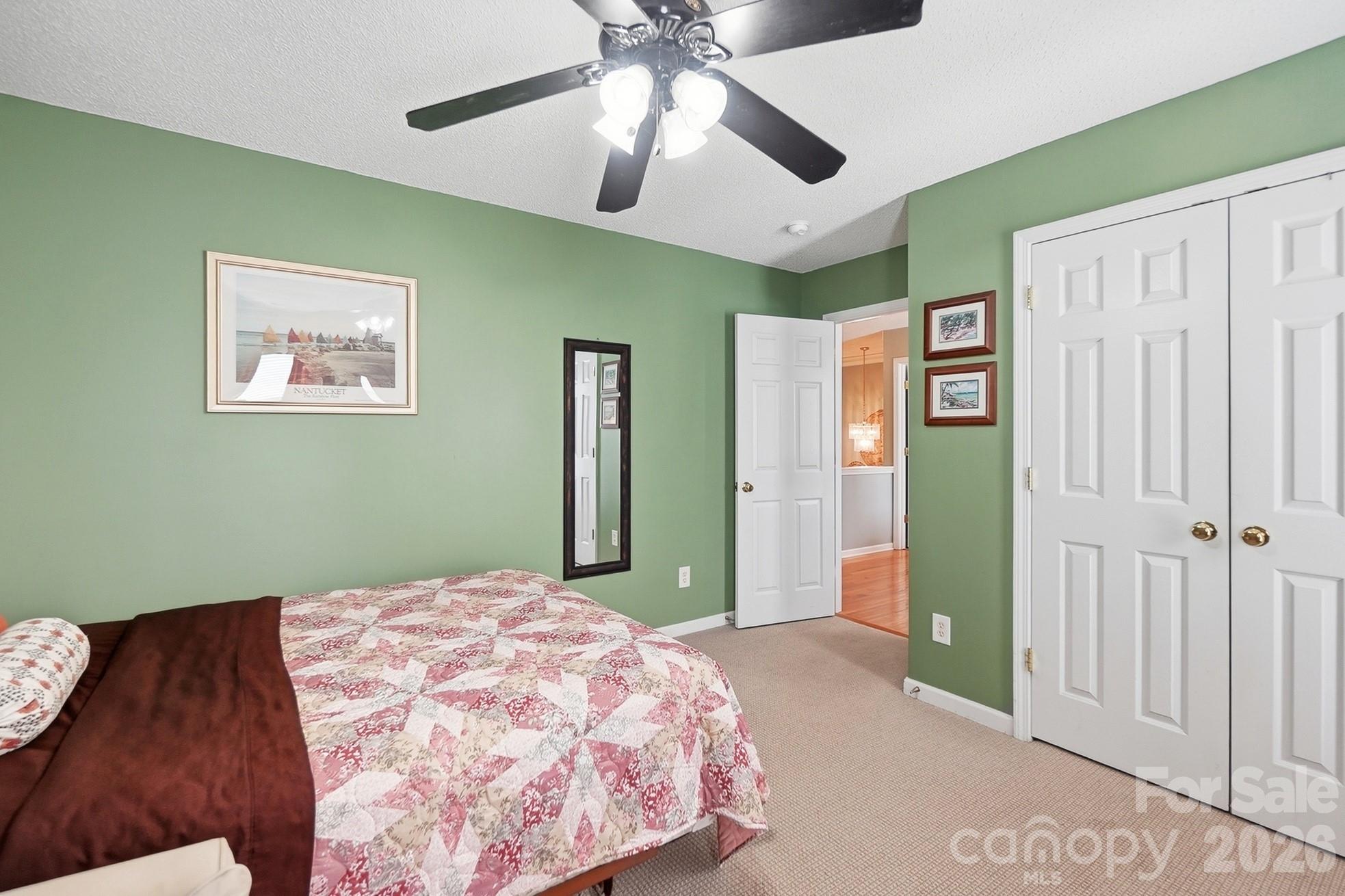 442 Sugar Maple Drive Tega Cay, SC 29708 - Photo 25 of 48 a bedroom with a large bed and a chandelier