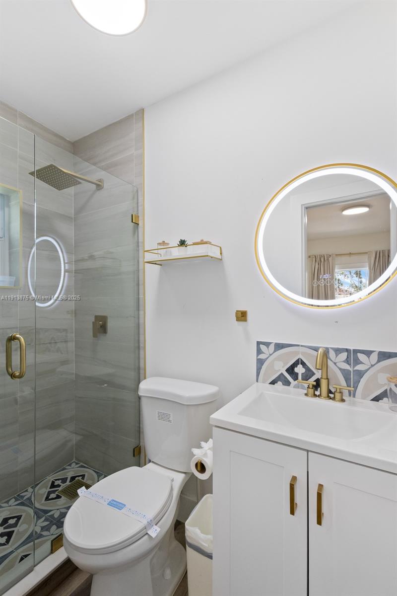 790 Northwest 60th Street Miami, FL 33127 - Photo 20 of 35 a white toilet sitting next to a bathroom sink