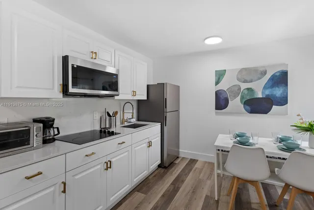 a kitchen with a sink cabinets and wooden floor