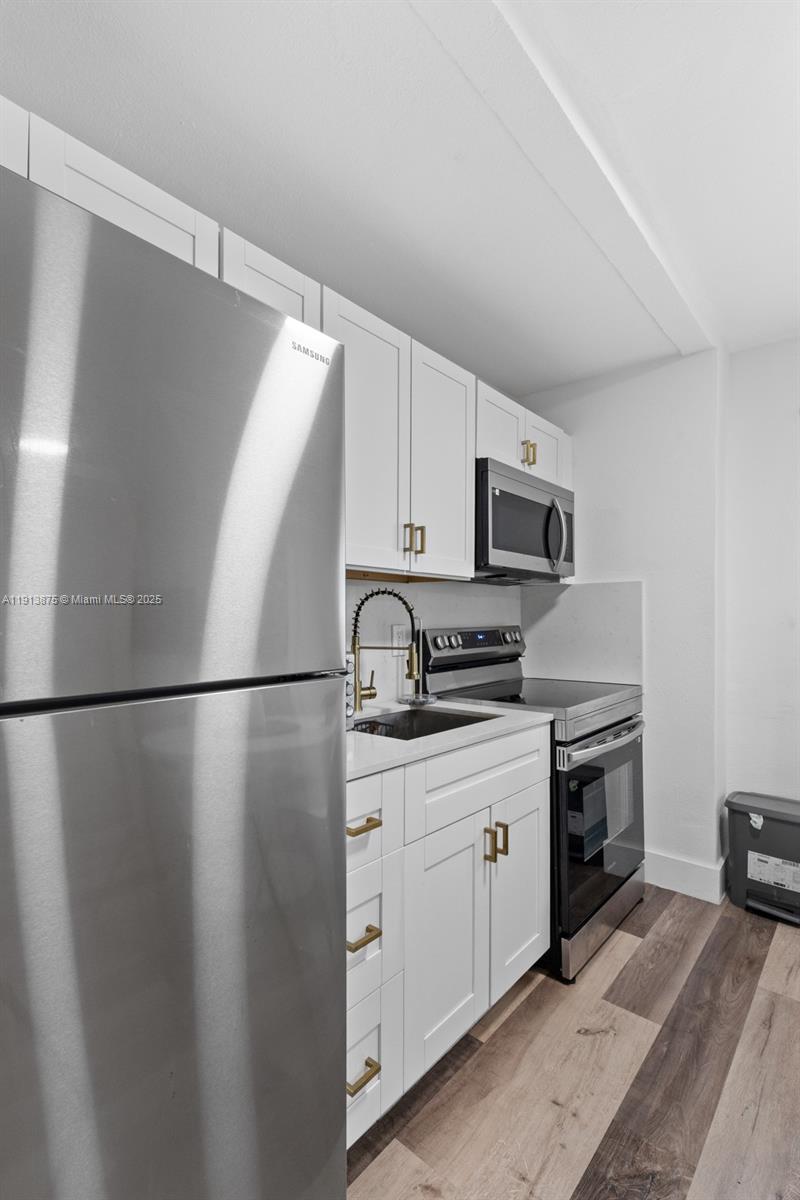 790 Northwest 60th Street Miami, FL 33127 - Photo 33 of 35 a kitchen with stainless steel appliances granite countertop a refrigerator a stove a sink and a microwave