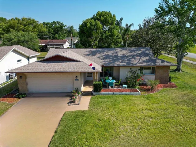 a view of a patio with table and chairs under an umbrella with a barbeque grill and plants